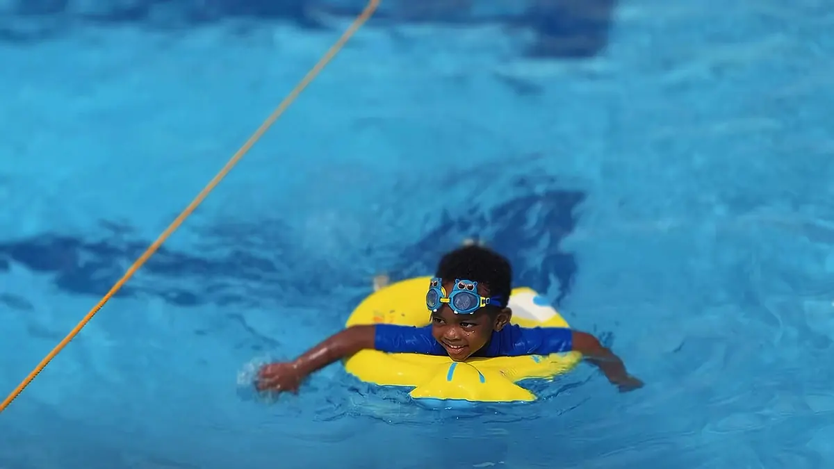 A Toddler child swimming during a school swim lesson