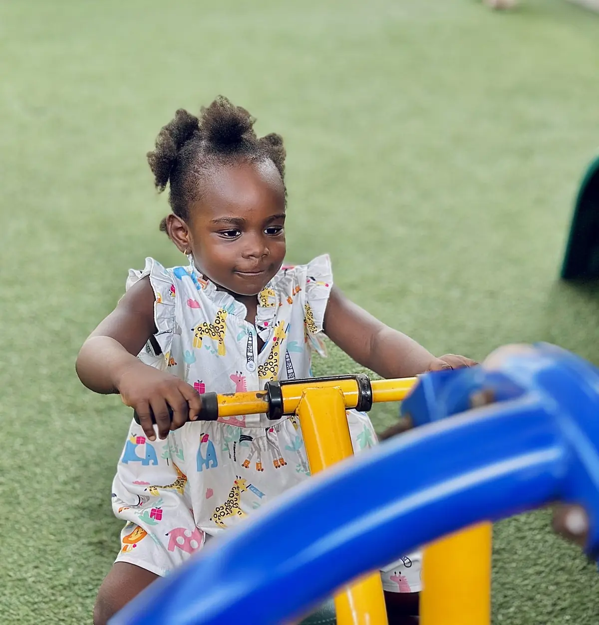 A toddler pushing a ride-on toy outdoors